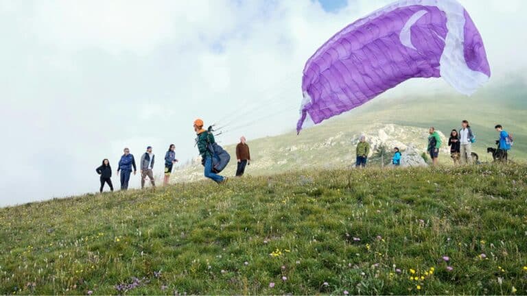 People watching paraglider take off