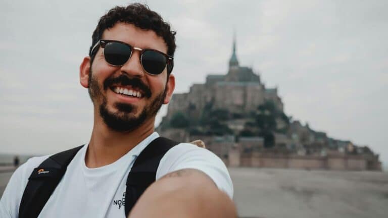 Man taking selfie in front of mont saint michael