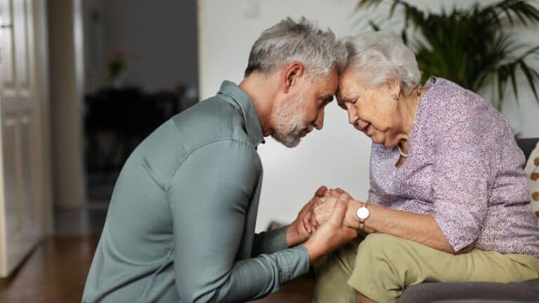 Mature man comforting elderly woman